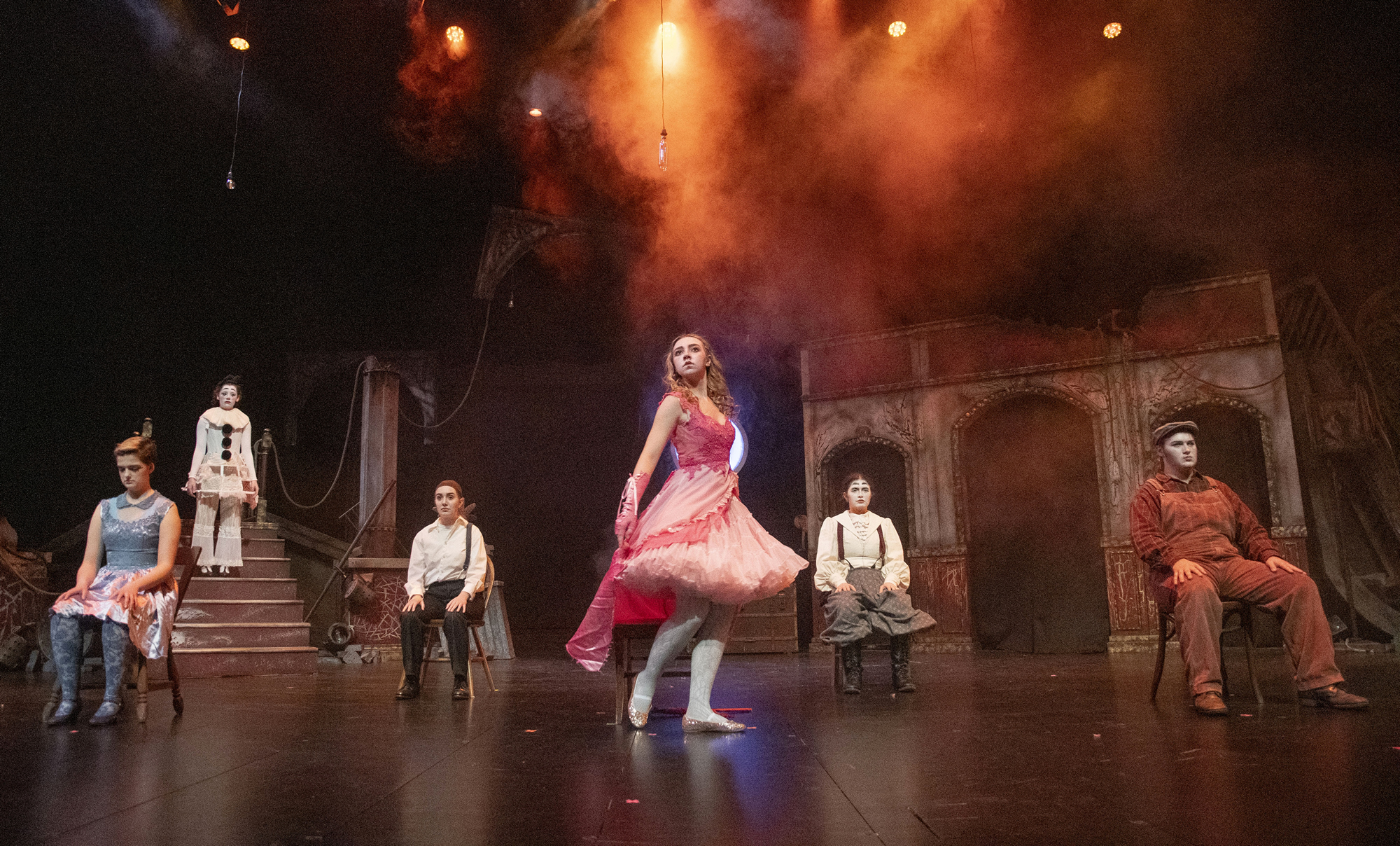 Theatre Production muitiple actors on stage with single person dancing